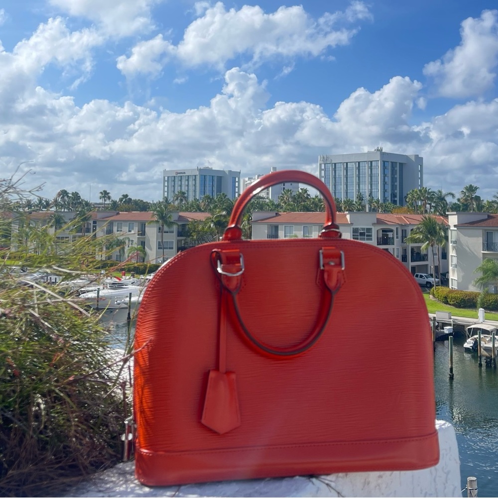 Louis Vuitton Alma Eli. In orange, with strap.